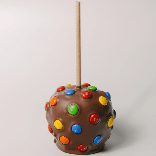 a chocolate candy apple with colorful candies on top