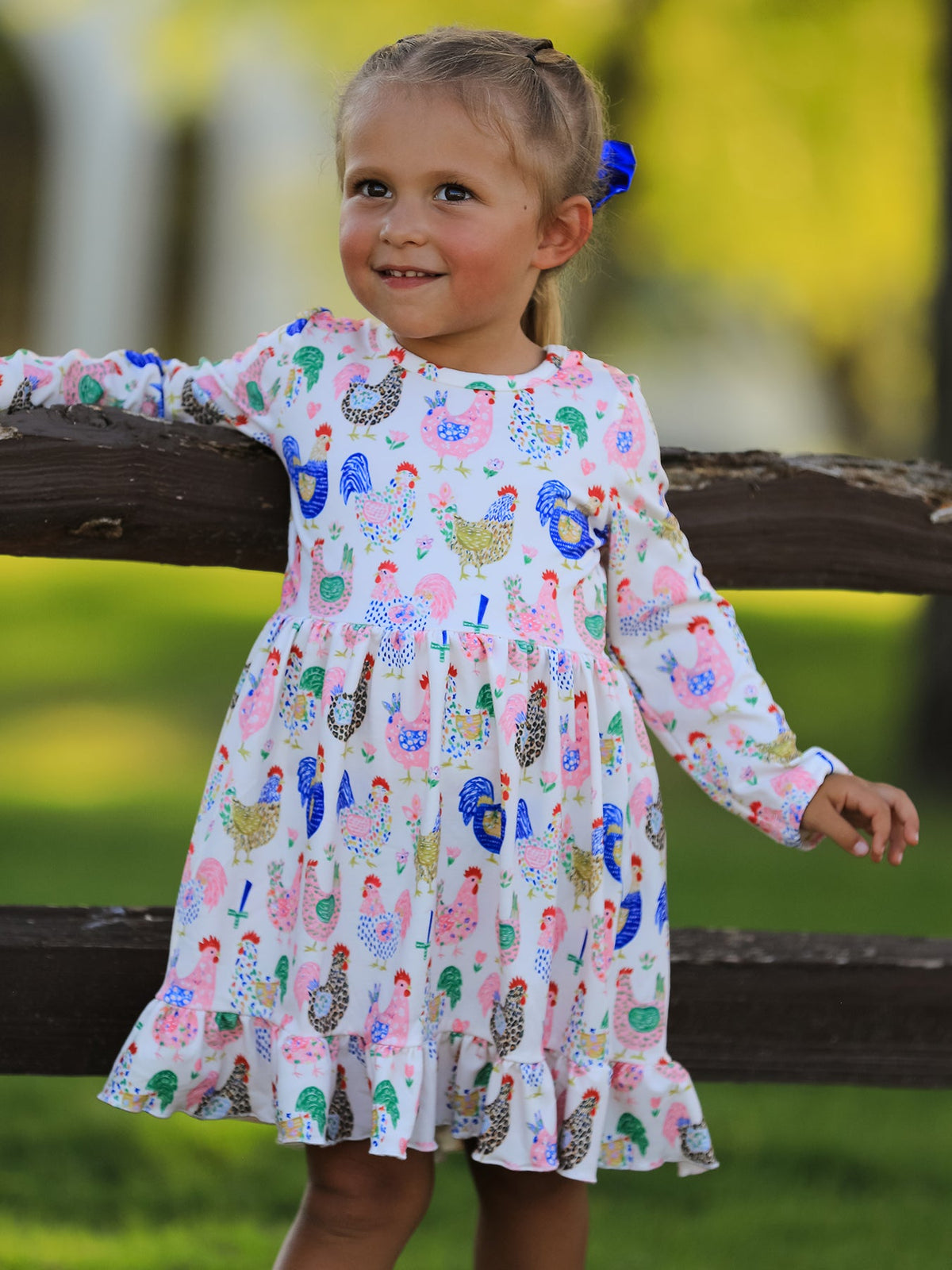 a girl leaning on a fence