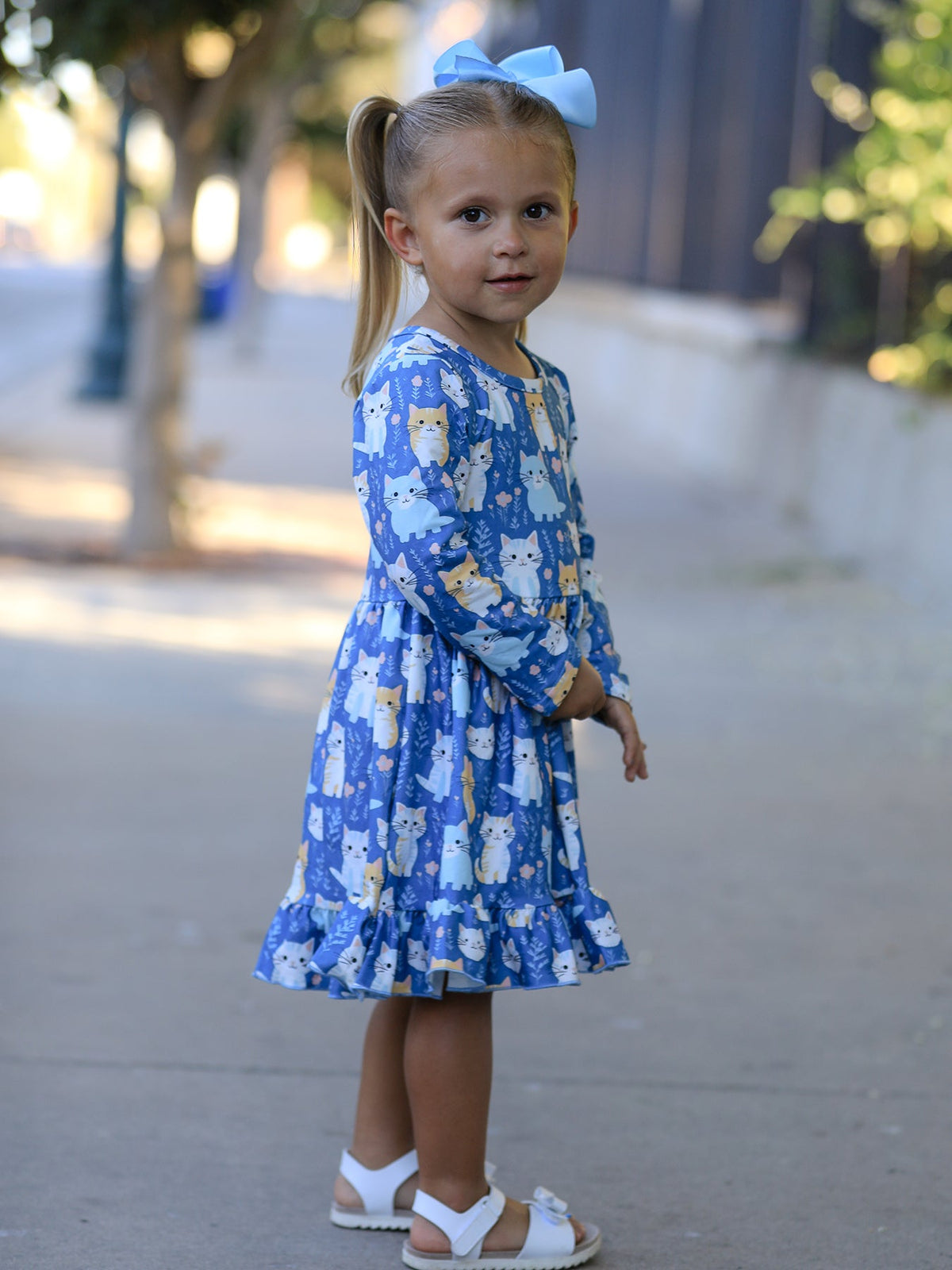 a girl standing on a sidewalk