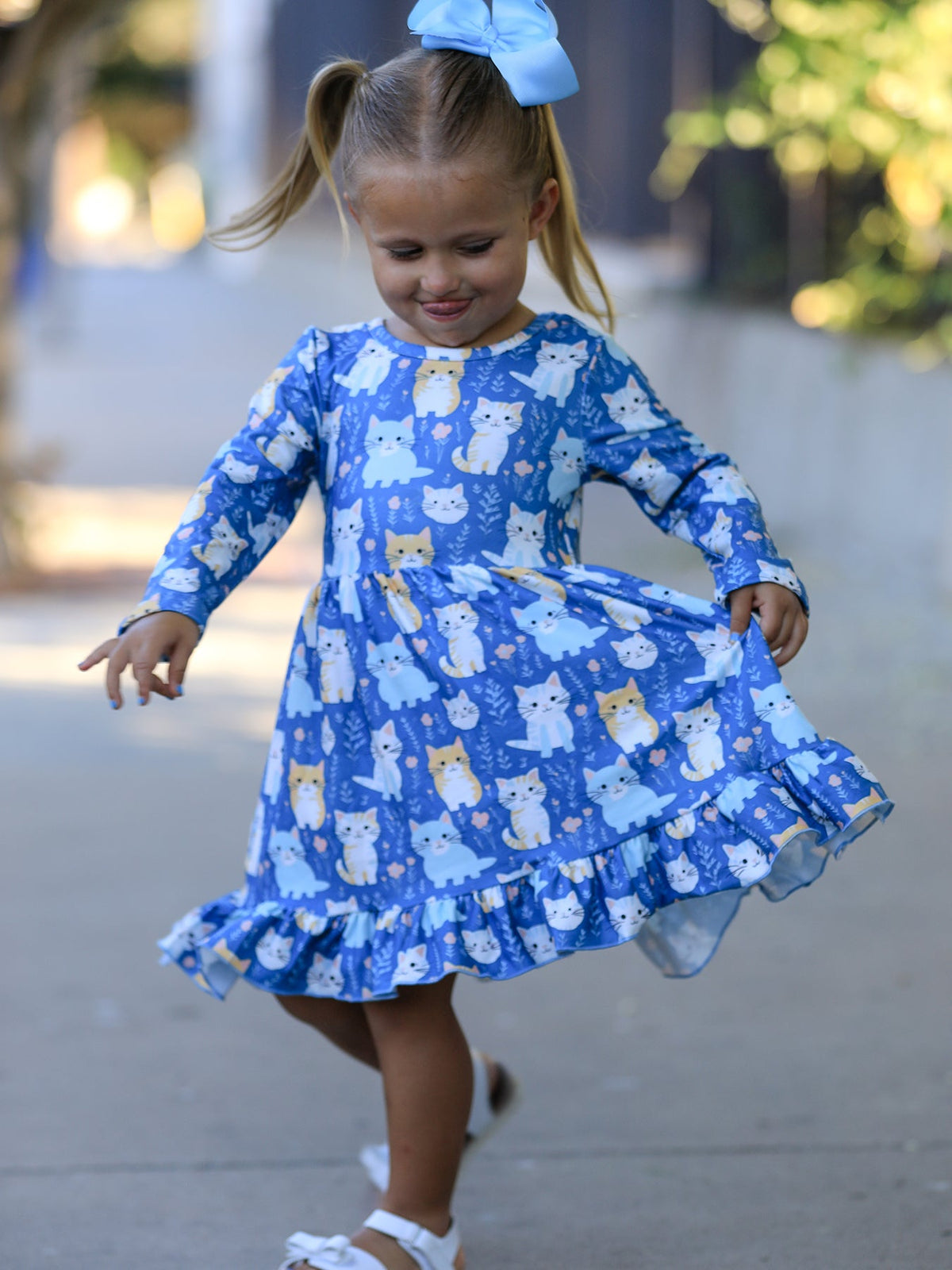 a girl wearing a blue dress with cats on it