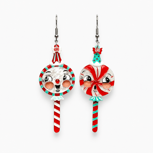 a pair of earrings with a face on them