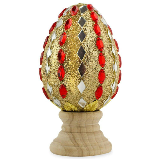 a gold and red egg with red gems