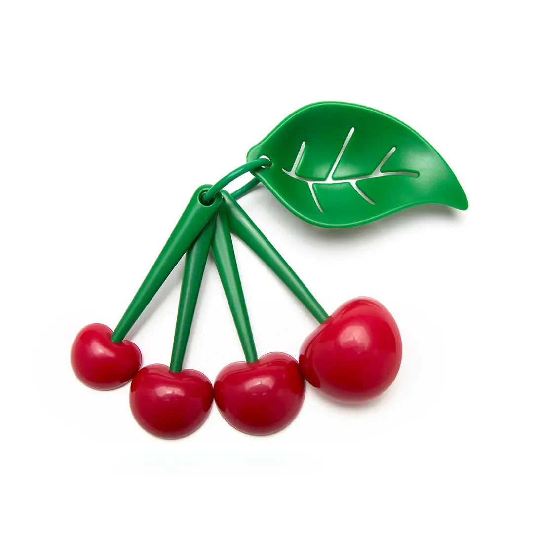 a group of cherries on a green leaf