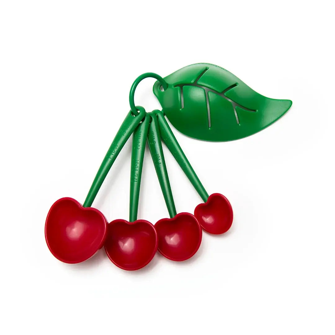 a spoons with red cherries and a green leaf