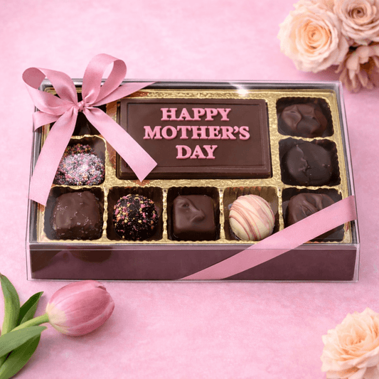 a box of chocolates with a pink ribbon and flowers