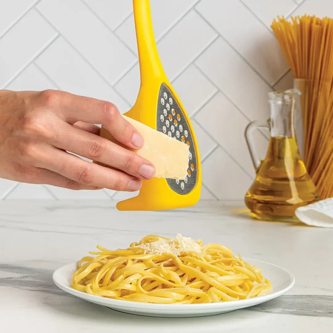a person grating a plate of pasta