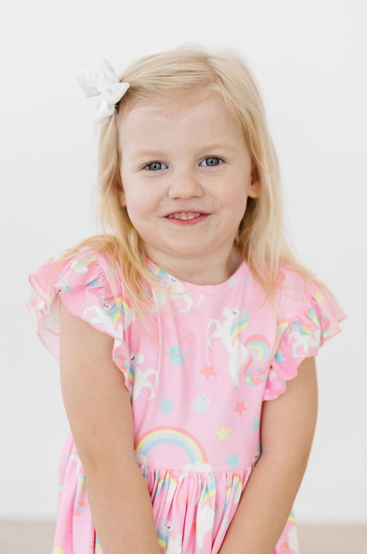 a girl with blonde hair and a white bow in her hair