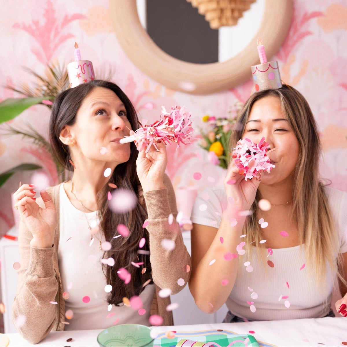a group of women blowing confetti