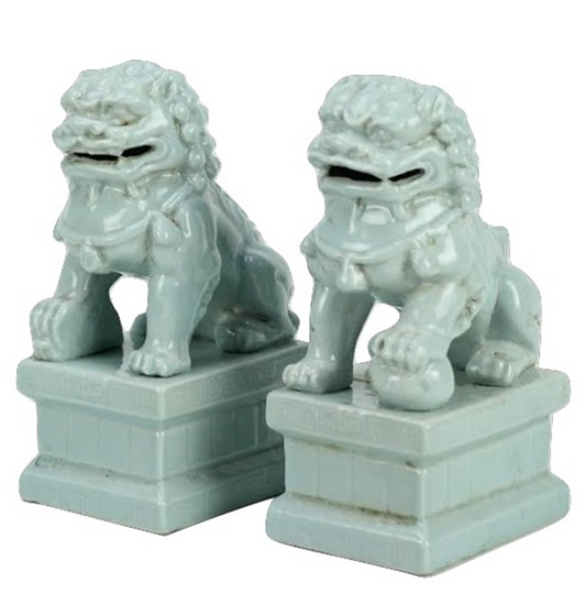 a pair of white lions on pedestals