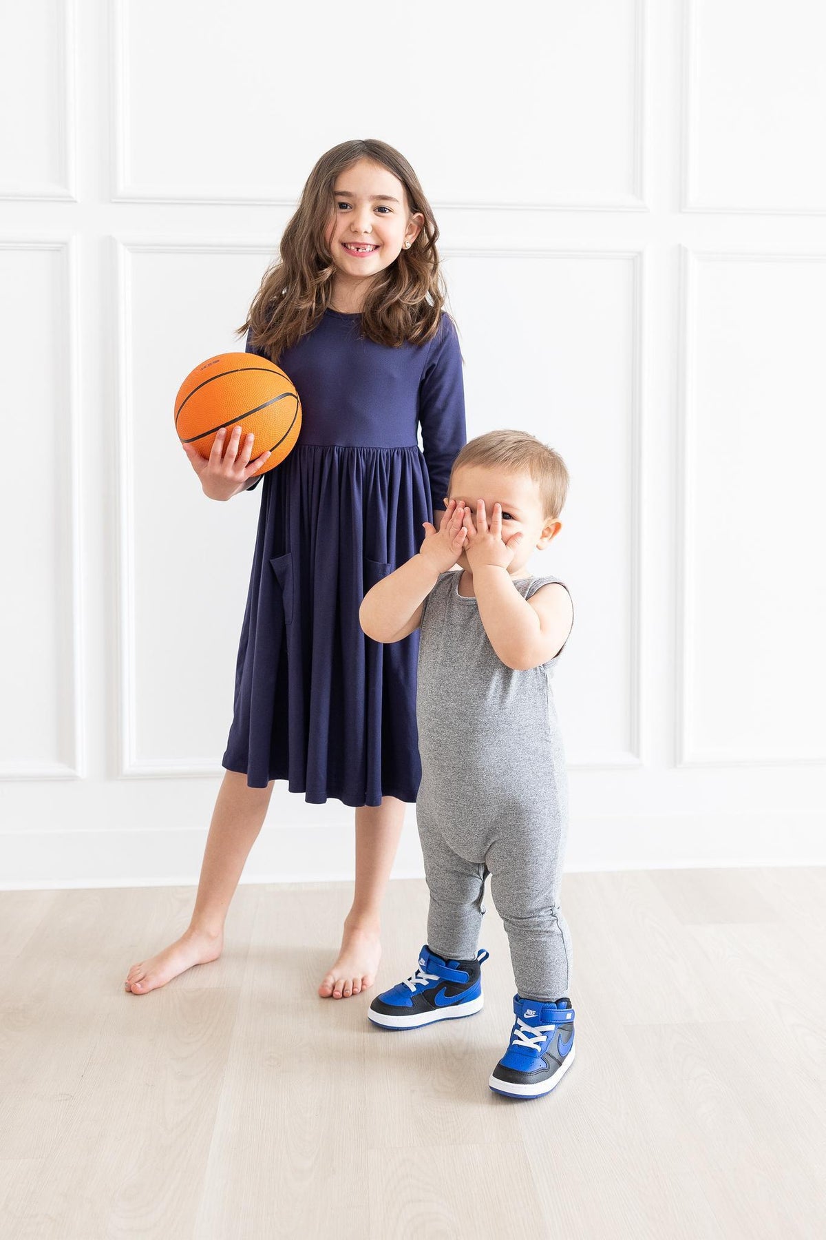 a girl and a boy holding a basketball