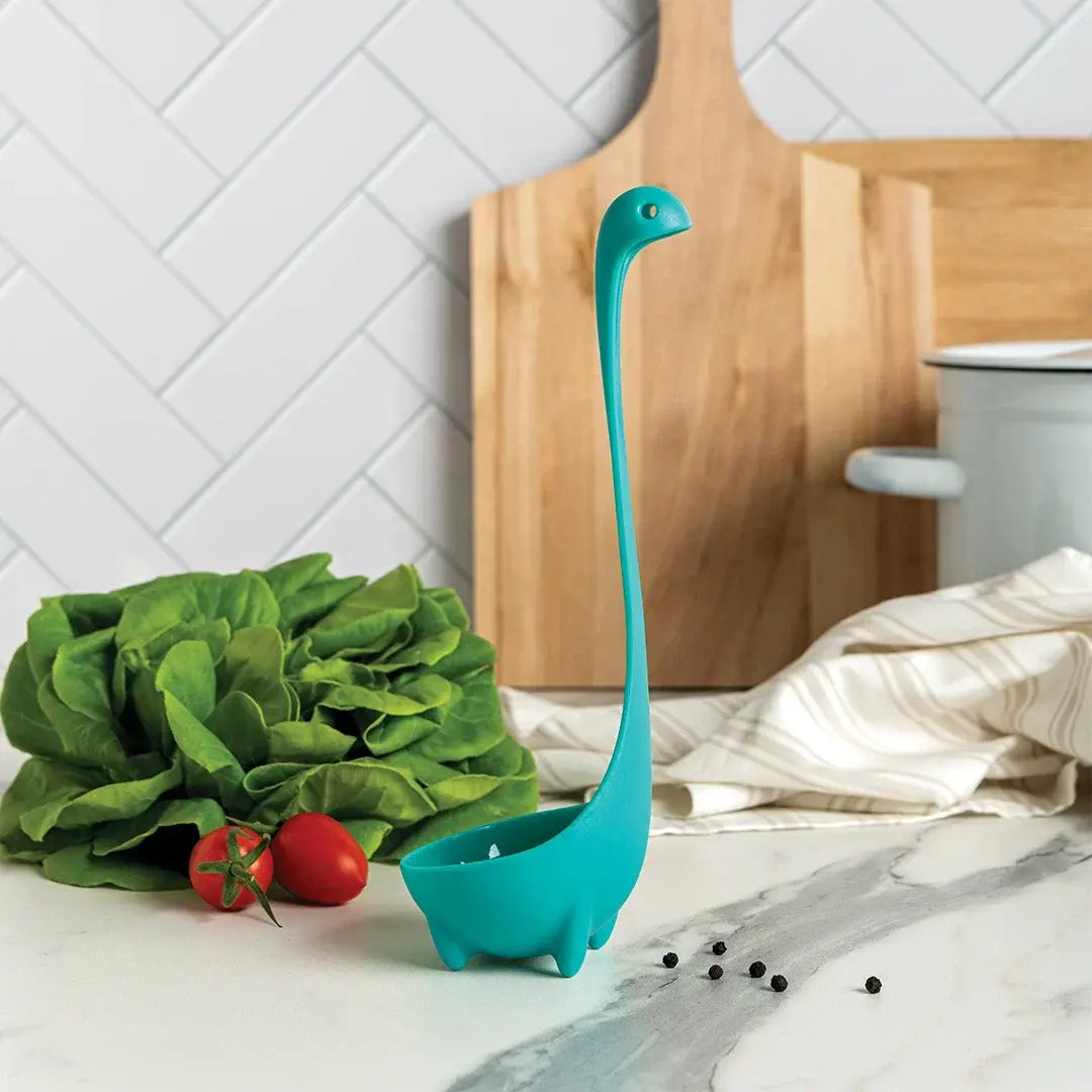 a blue dinosaur shaped object next to vegetables