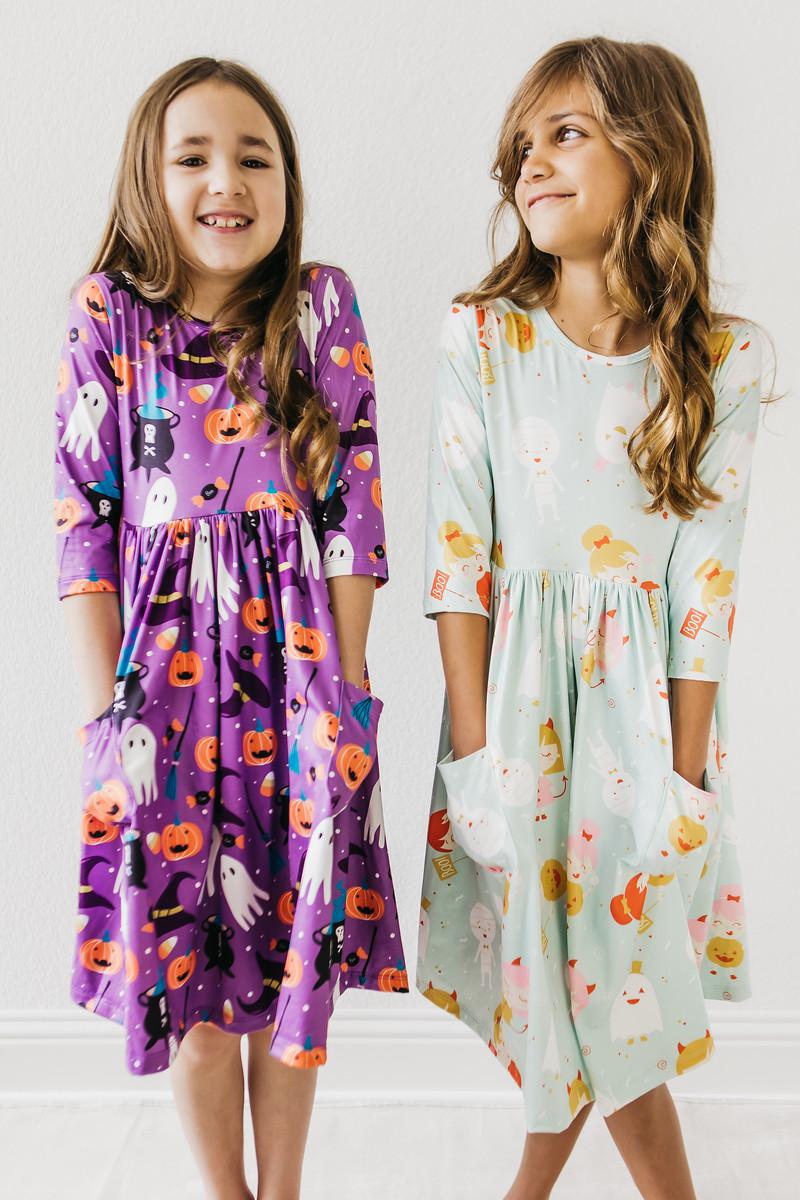 two girls wearing dresses