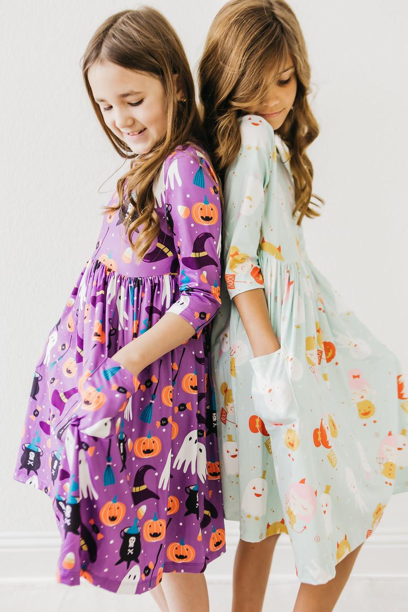 two girls in dresses with halloween designs