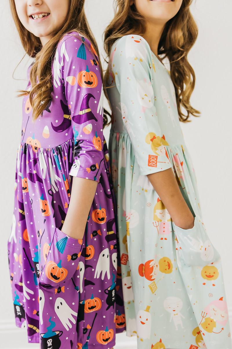 two girls wearing dresses
