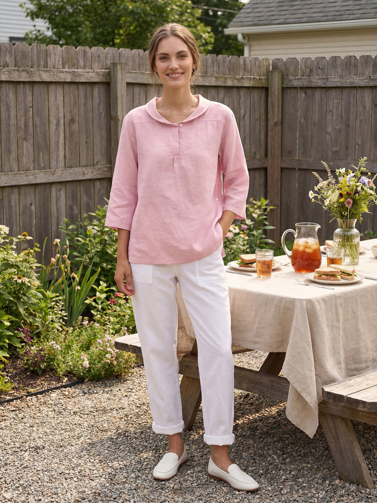 a woman standing in front of a table with food and drinks