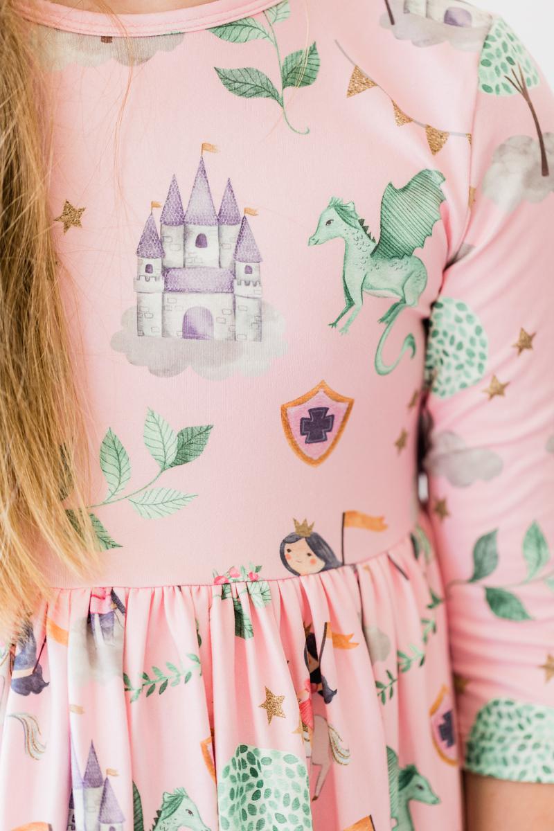 a girl wearing a pink dress with drawings on it
