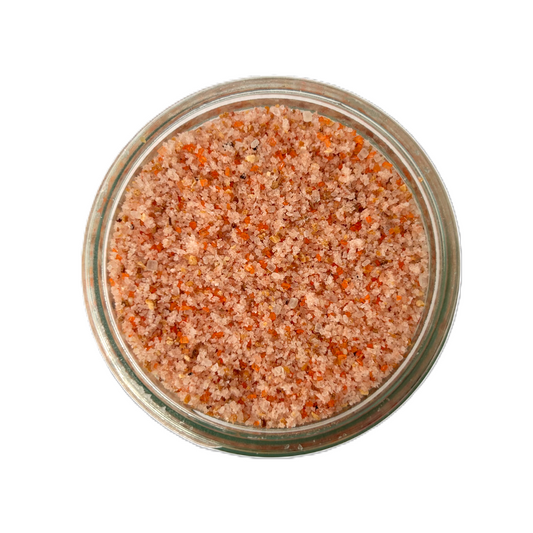 a glass container with orange and white salt