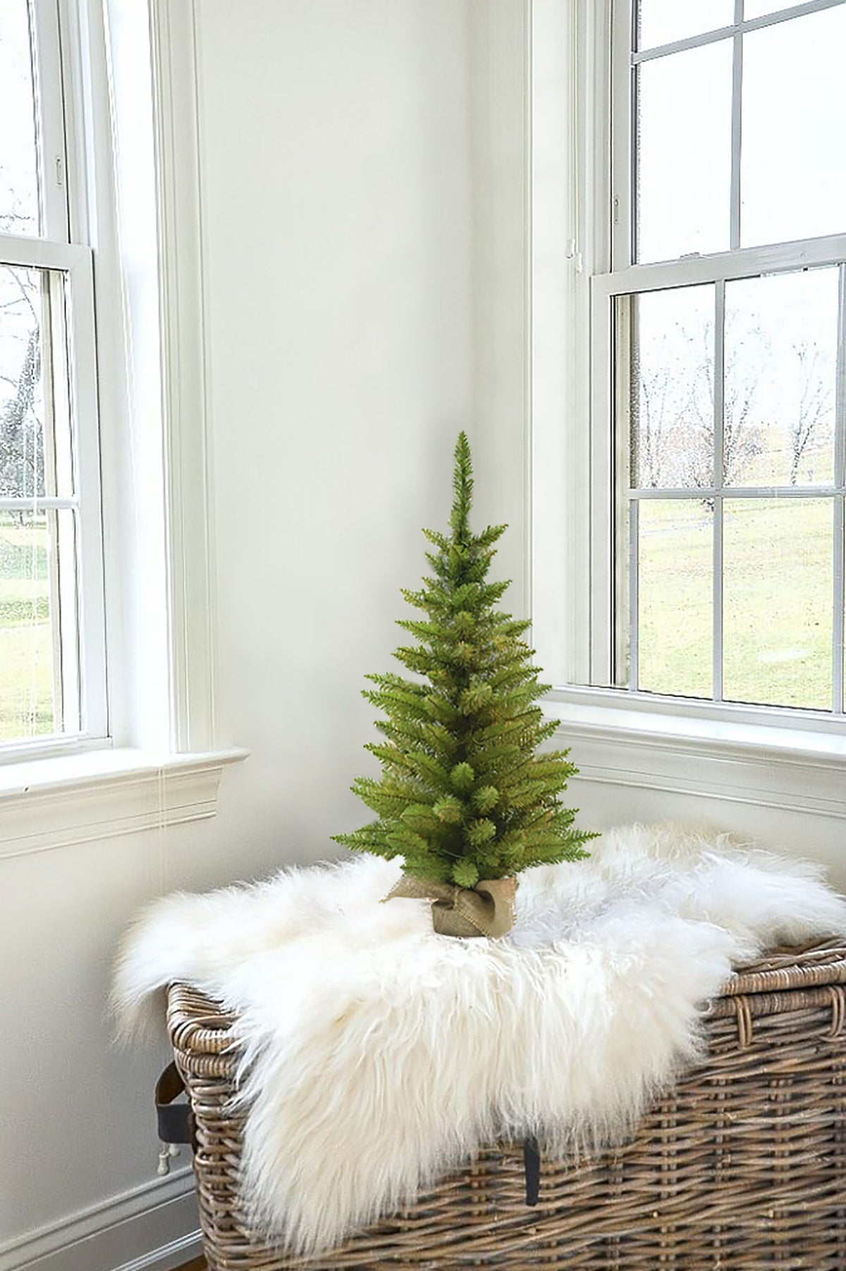 a small christmas tree on a bench in a corner of a room