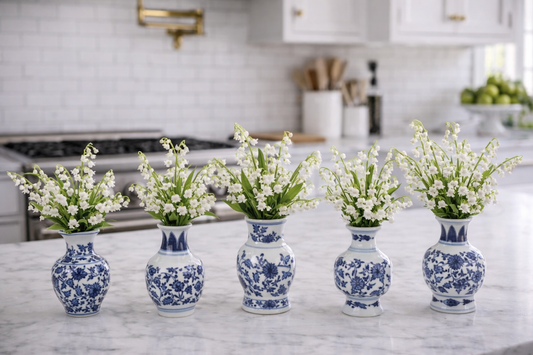 a row of blue and white vases with white flowers