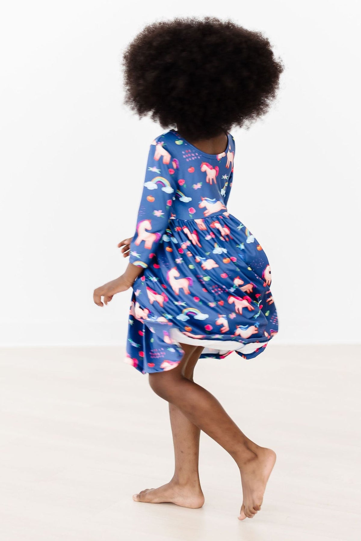 a girl wearing a blue dress with a unicorn print on it