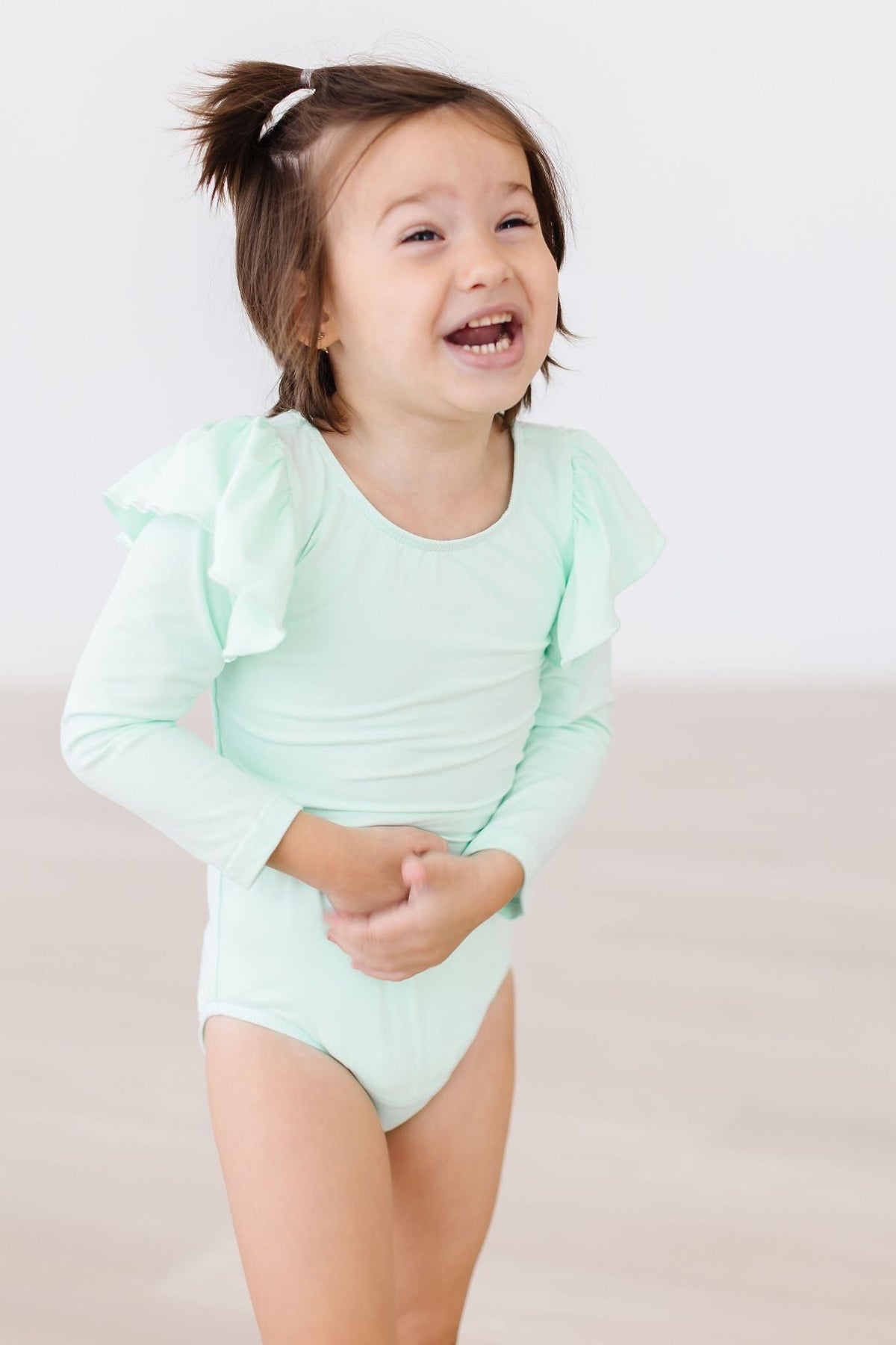 a child laughing with hands on stomach