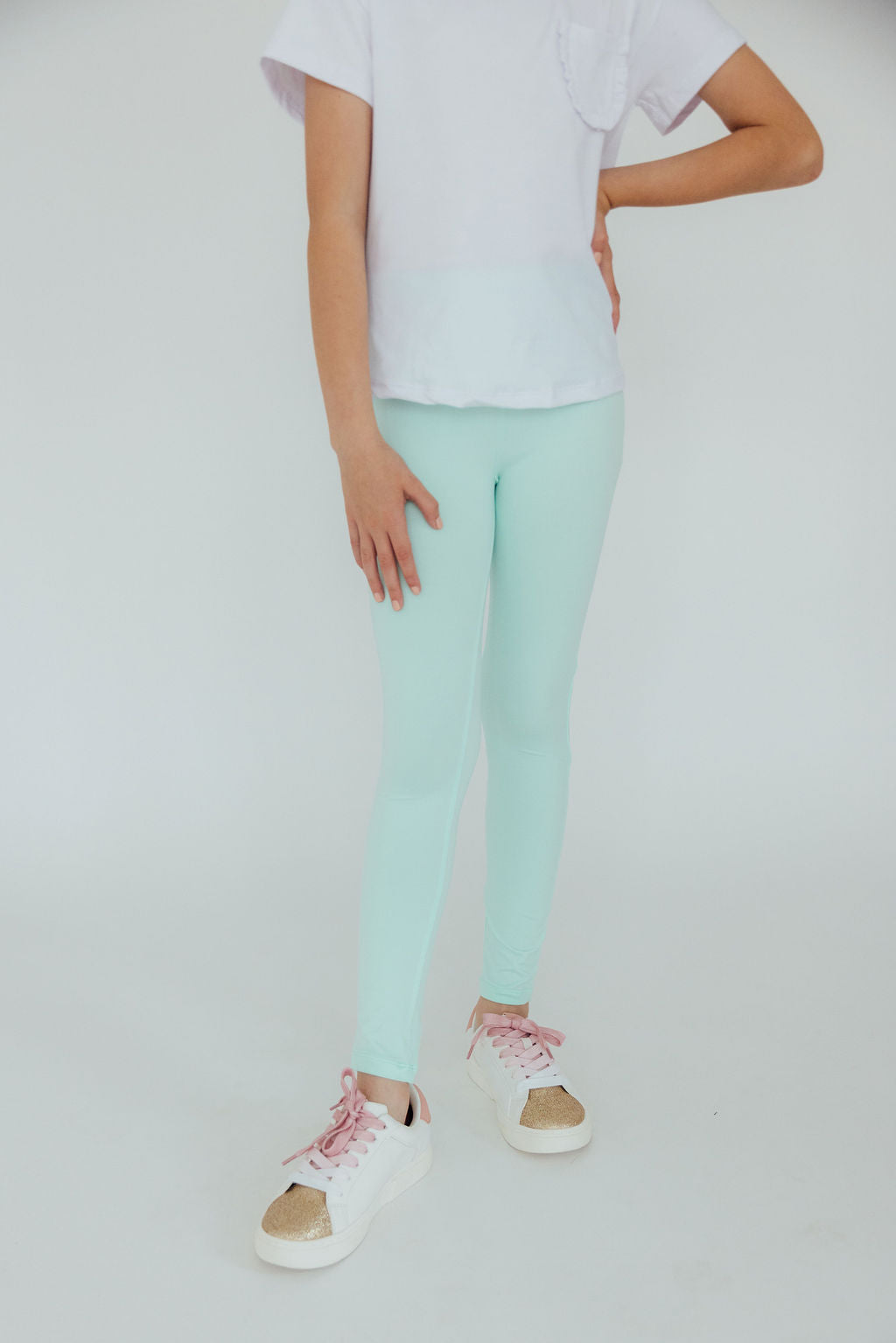 a person wearing light blue leggings and white shirt