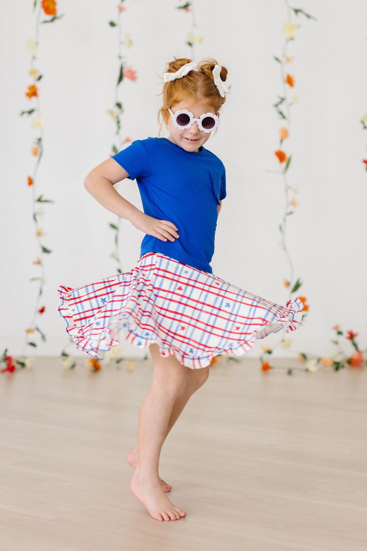 a girl wearing white sunglasses and a skirt