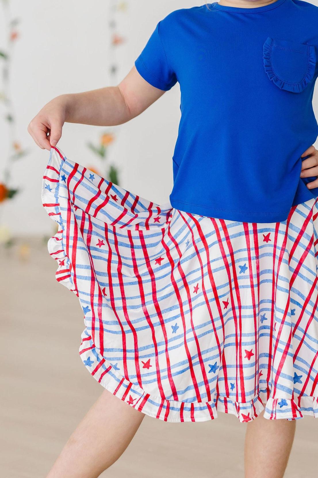 a person in a blue shirt and red and white striped skirt