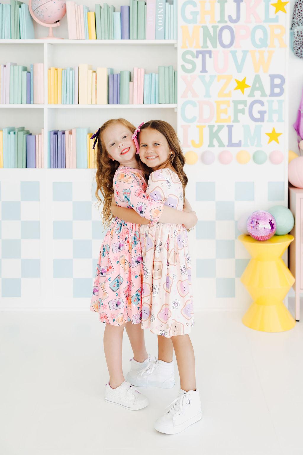 two girls hugging each other in a room with bookshelves