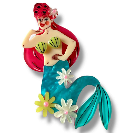 a mermaid pin with flowers and a tail