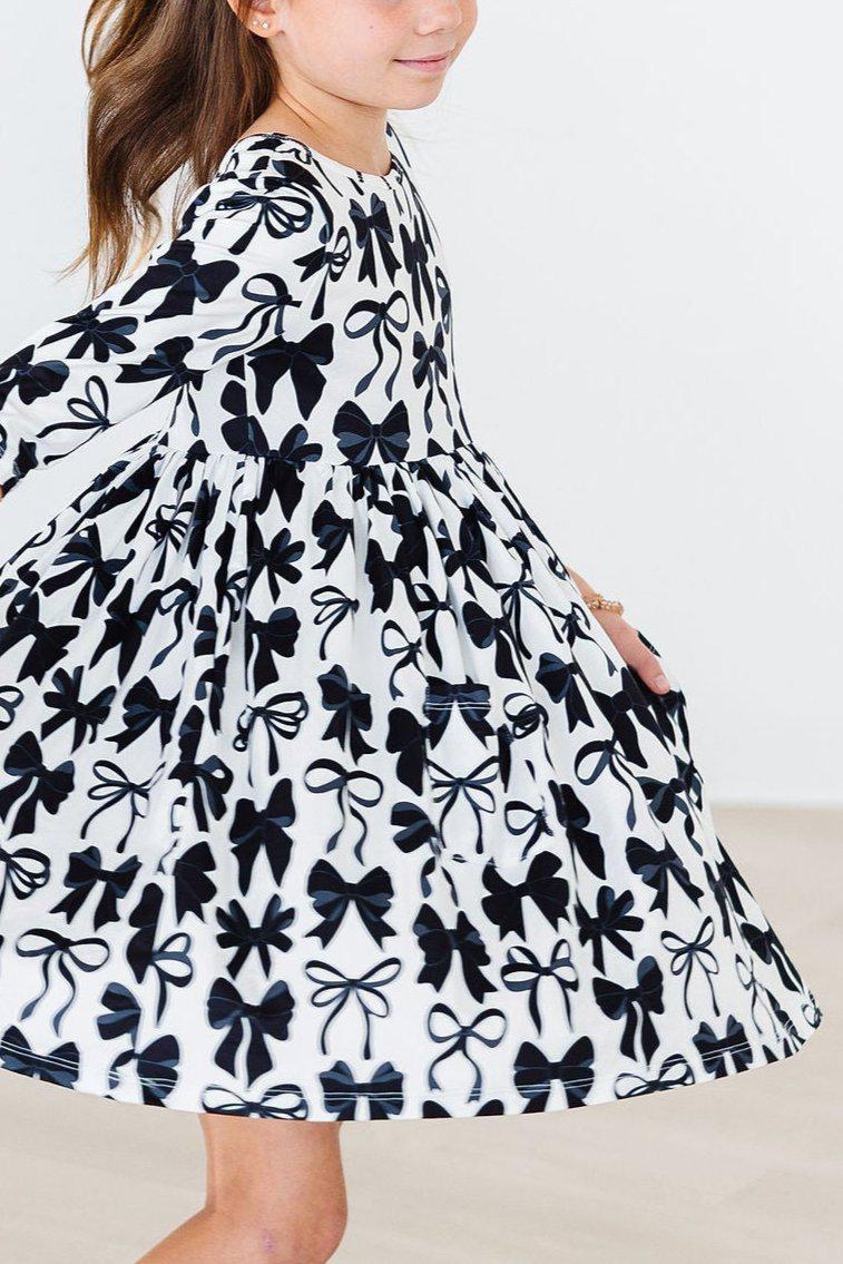 a girl wearing a dress with bows