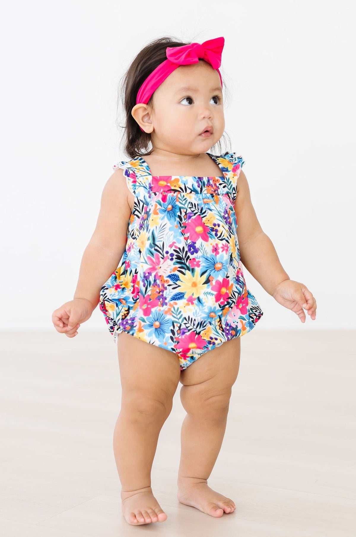 a baby girl wearing a flowered swimsuit