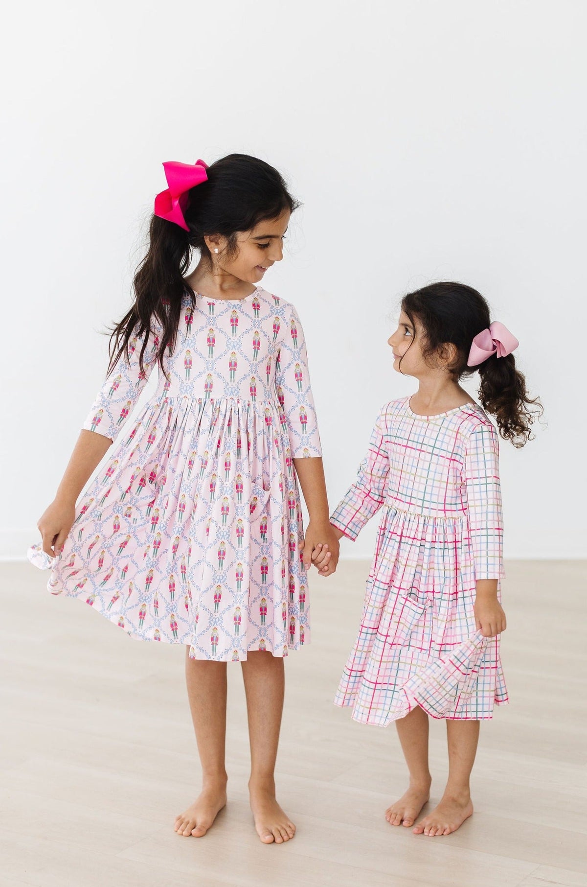 two girls holding hands and looking at each other
