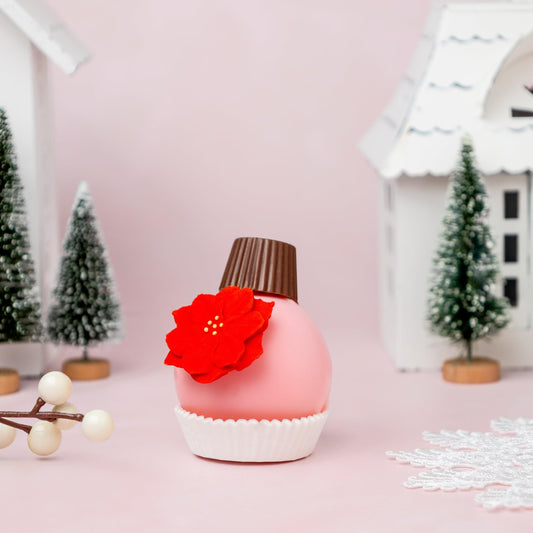 a pink object with a red flower on it next to a white snowflake and small trees