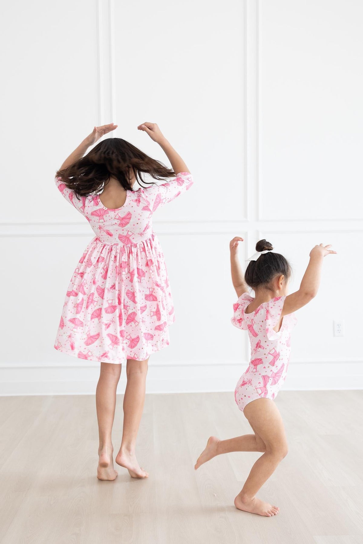 two girls in pink dresses dancing