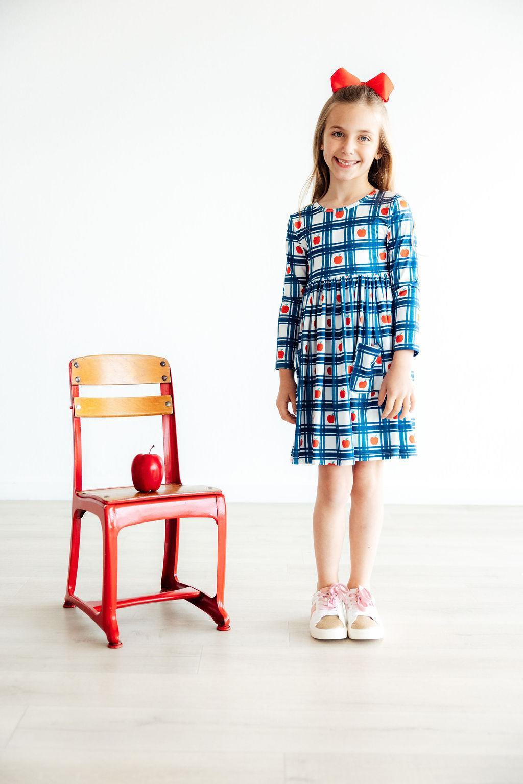 a girl standing next to a chair