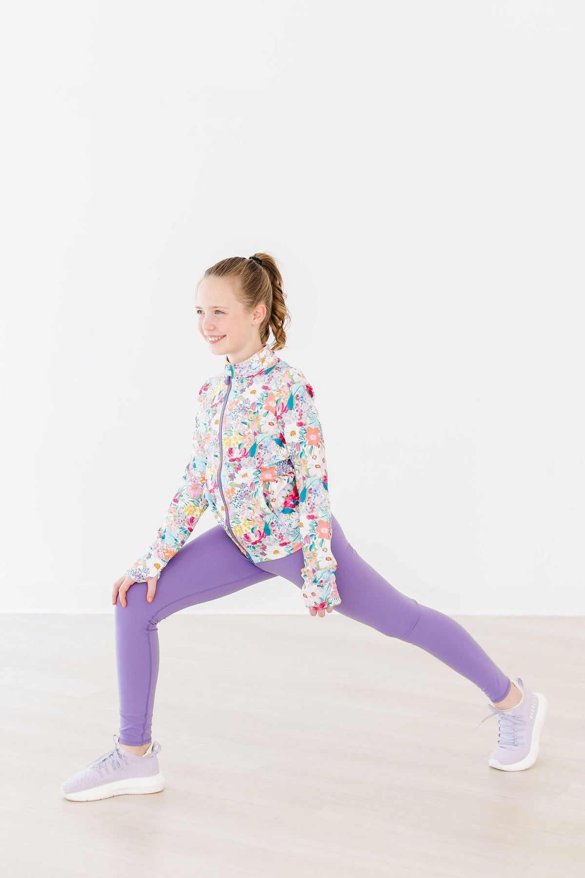 a girl in a floral jacket and purple leggings