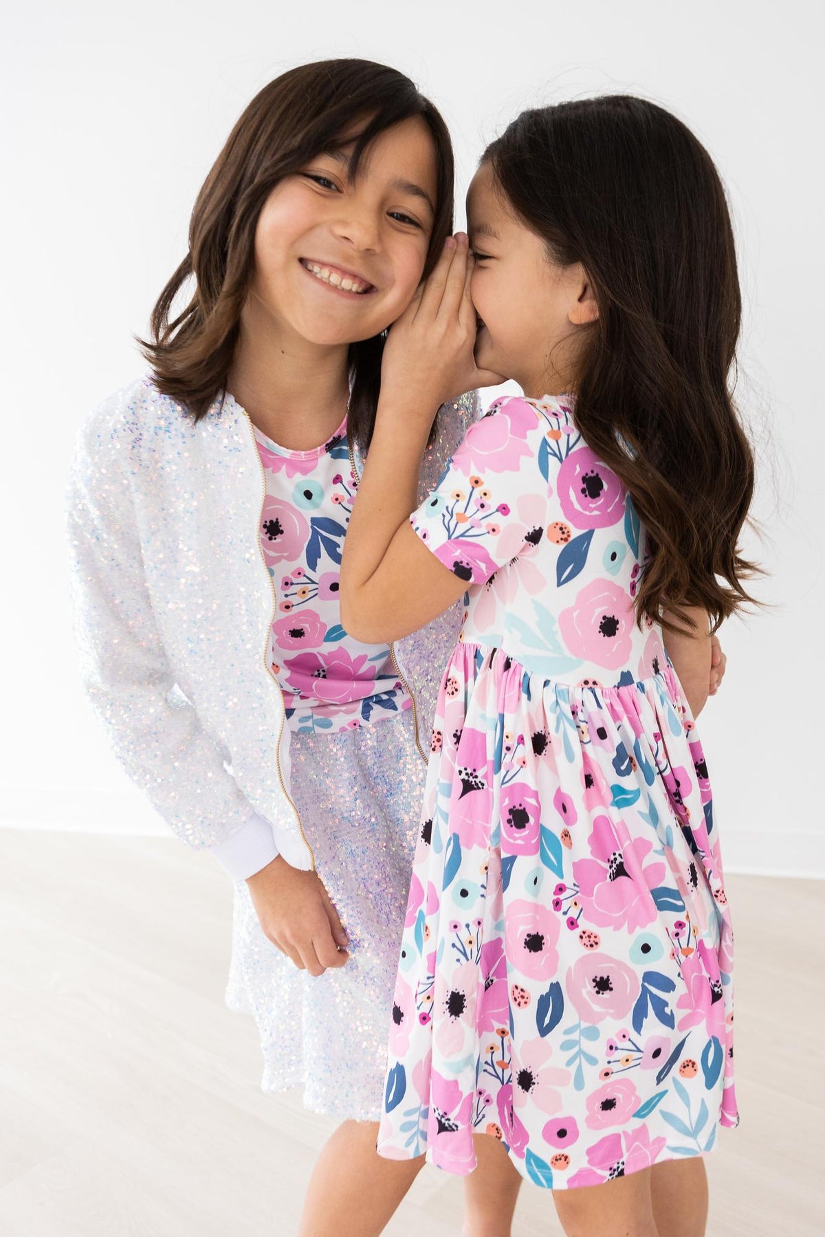 two girls whispering into each other