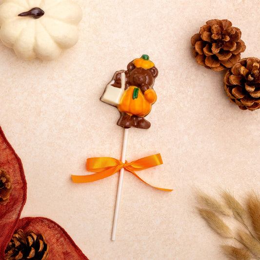 a candy on a stick next to pine cones
