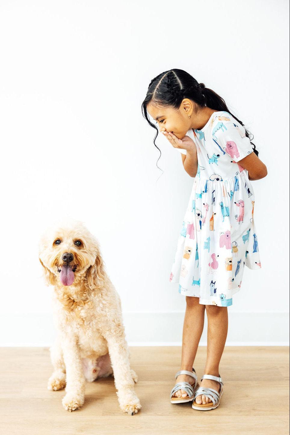 a girl with her hand over her mouth and a dog