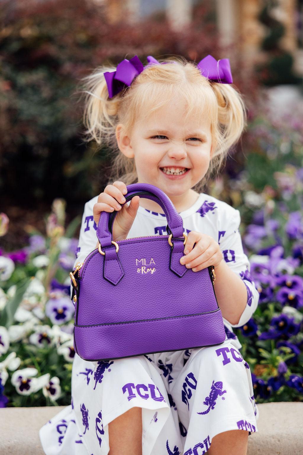 a girl holding a purple purse