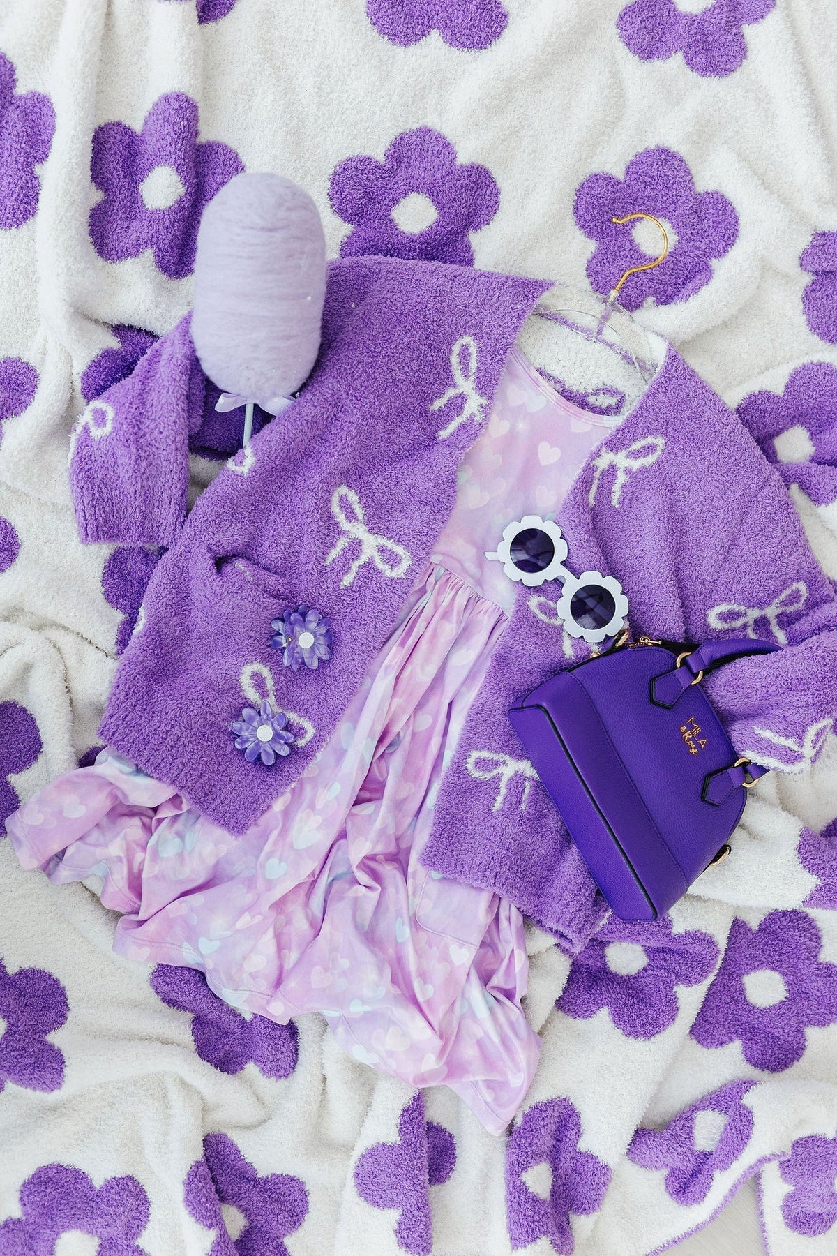 purple and purple outfit on a white and purple blanket