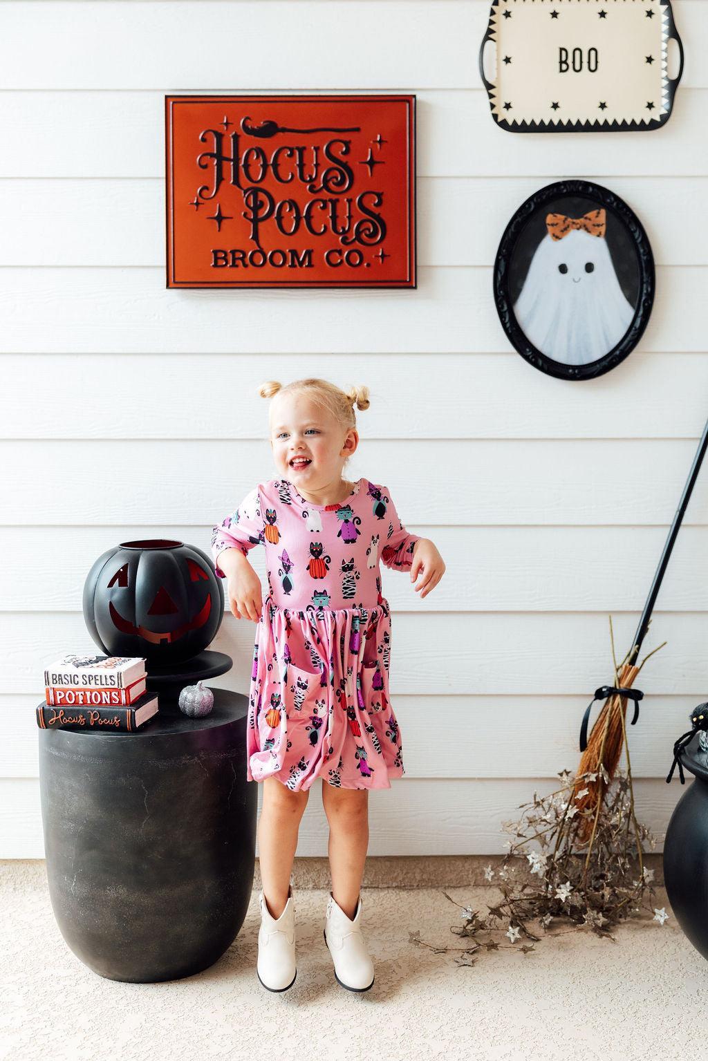a girl standing next to a pumpkin