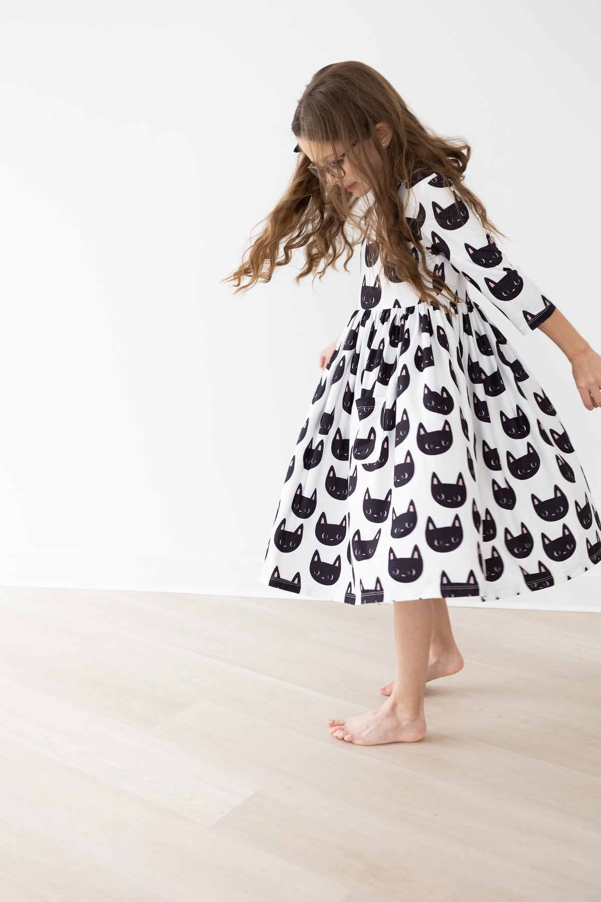 a girl wearing a dress with cats on it