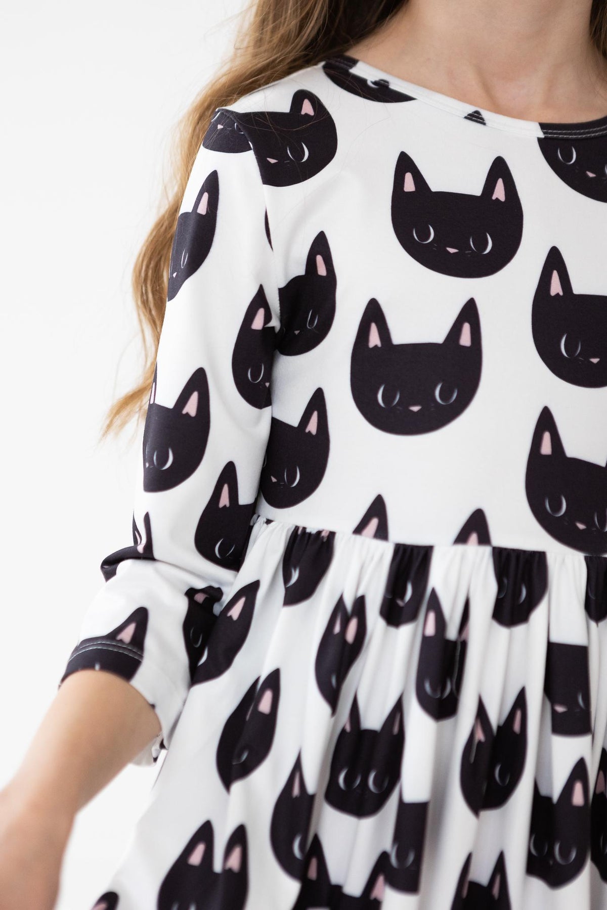 a girl wearing a dress with cat faces