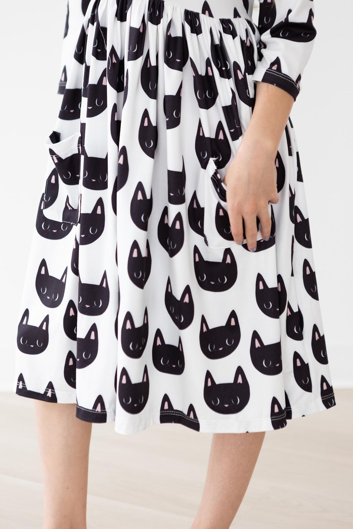 a person wearing a dress with cats on it