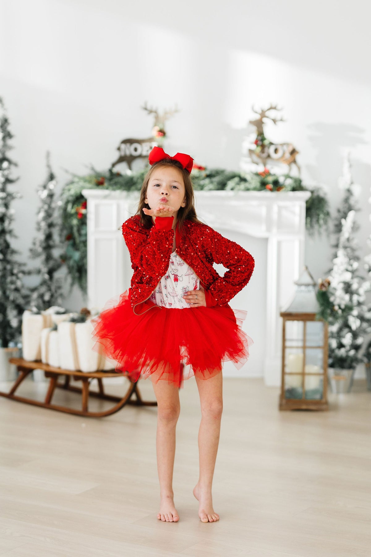 a girl in a red dress blowing a kiss
