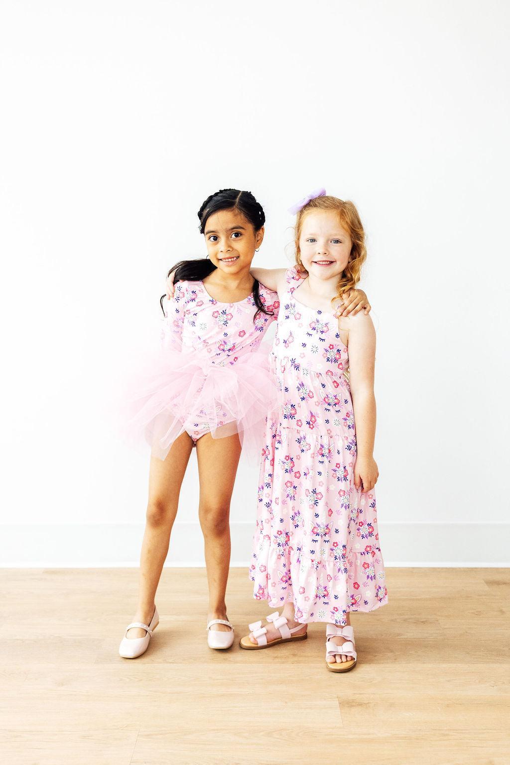 two girls in dresses posing for a picture