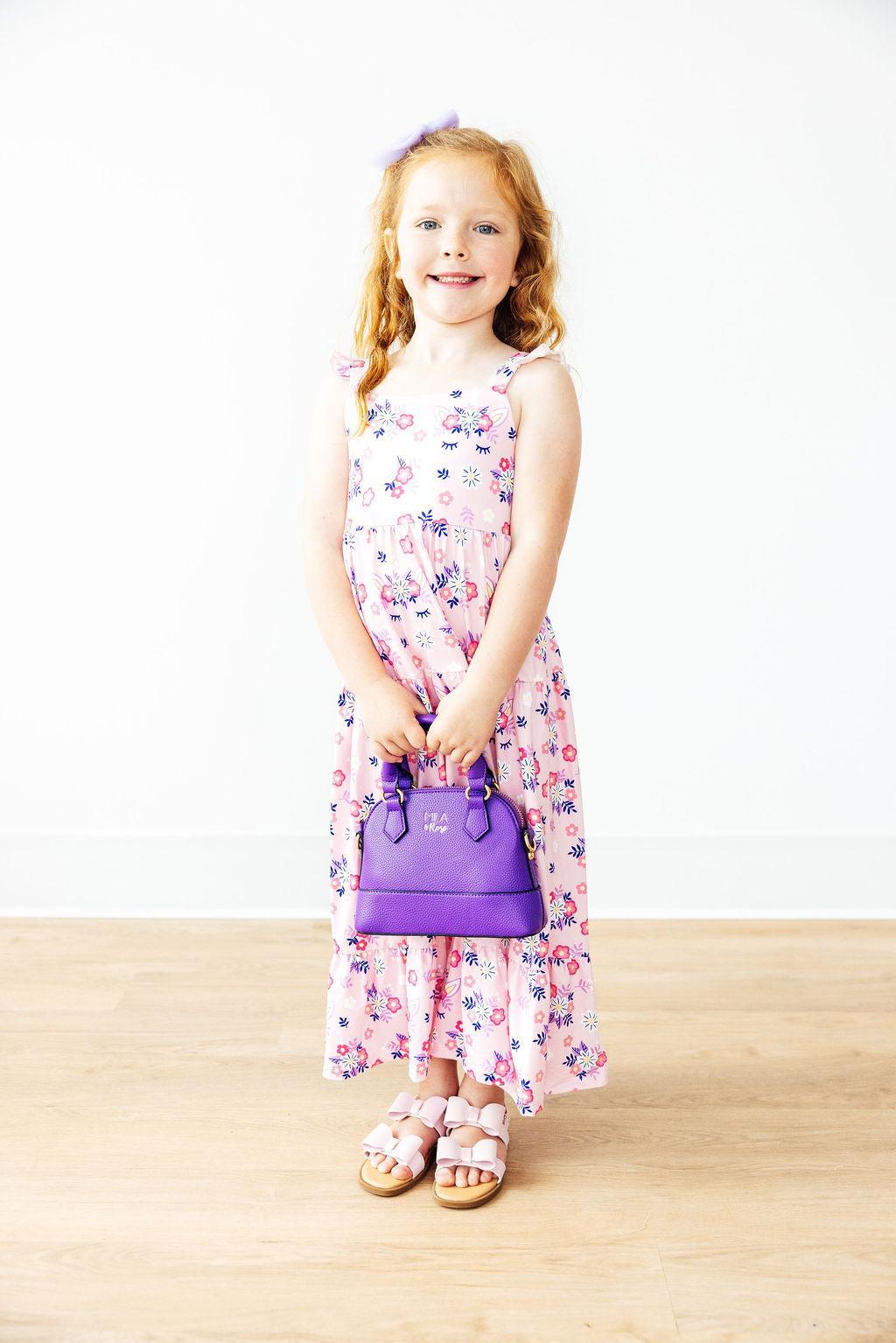 a girl holding a purple purse
