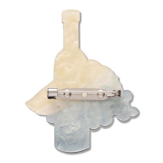 a brooch with a glass bottle and a glass object
